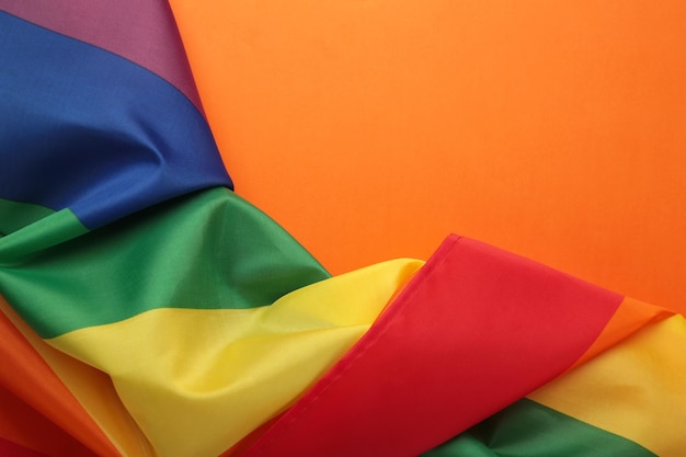 A bandeira do arco-íris lgbt em fundo laranja vista superior espaço para texto