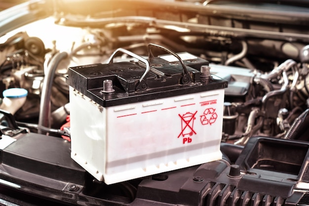 Foto a bateria do carro do sistema elétrico do automóvel no compartimento do motor para manutenção do carro e reciclagem de lixo eletrônico