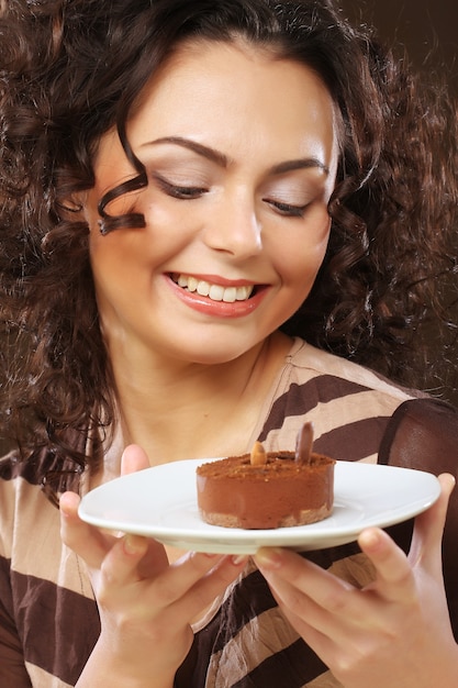 Foto a bela jovem sorridente com um bolo
