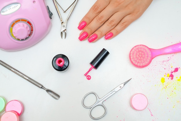 A bela manicure closeup no salão em um fundo branco isola o conceito de beleza e saúde