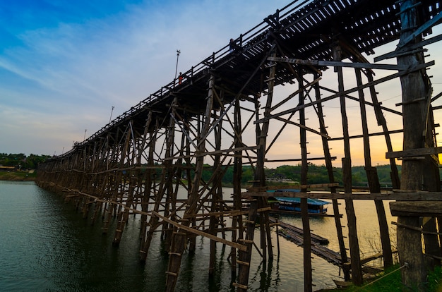 A bela ponte de madeira com o nascer do sol e nevoeiro no sangklaburi em kanchanaburi, tailândia