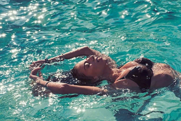 A beleza da mulher é hidratada Mulher sexy no mar do Caribe nas Bahamas Relaxe na piscina do spa refresco e cuidados com a pele Férias de verão e viaje para o oceano Maldivas ou água da praia de Miami