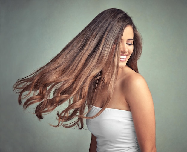 A beleza natural não precisa de introdução Foto de estúdio de uma linda mulher com longas madeixas posando contra um fundo cinza