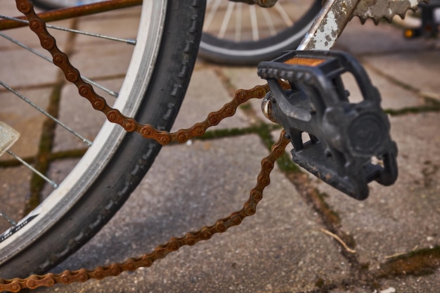 Foto a bicicleta azul esteve do lado de fora durante todo o inverno e quebrou a corrente da bicicleta enferrujada pendurada na roda dentada e