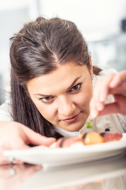 Foto a boa chef feminina dá um toque final ao prato.