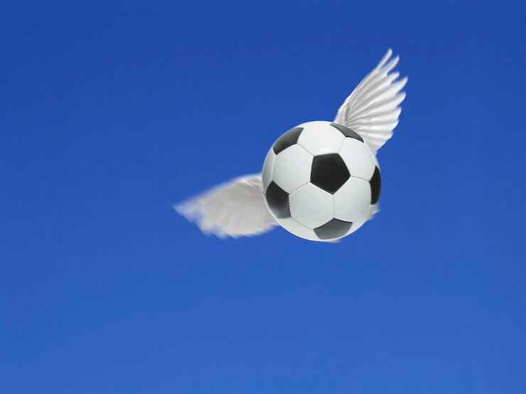 Foto a bola de futebol tem asas voando no ar no céu azul