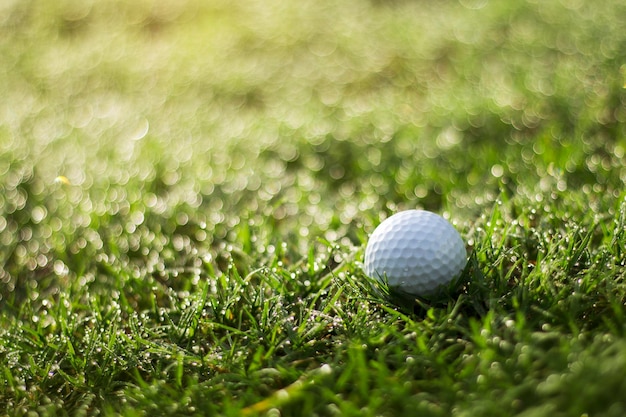 A bola de golfe está em um gramado verde em um belo campo de golfe