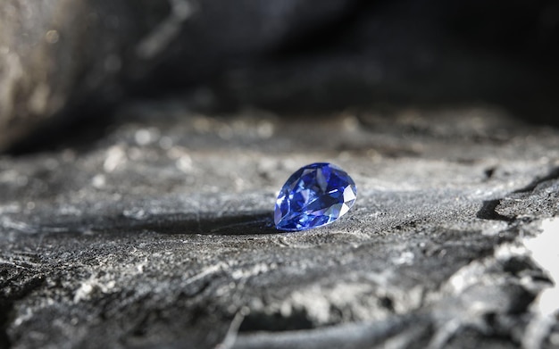A brilhante pedra preciosa de safira púrpura natural em uma superfície rochosa