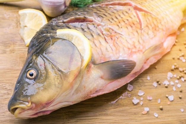 A cabeça de um peixe carpa em uma tábua