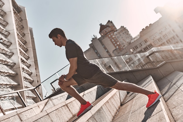 A caminho de uma ótima forma. Jovem com roupas esportivas se aquecendo