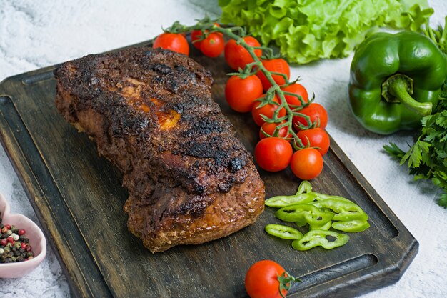 A carne de porco cozida desbastou em um molho da noz e de hortelã em uma placa de corte com ervas e os vegetais frescos.