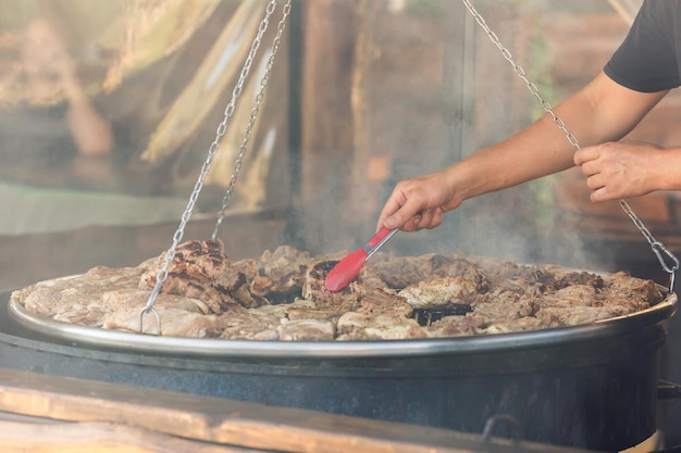 A carne é frita na grande grelha no café de rua