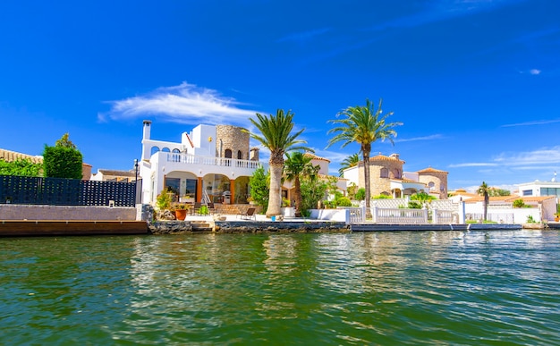 A casa com palmeira perto da água no resort na Espanha