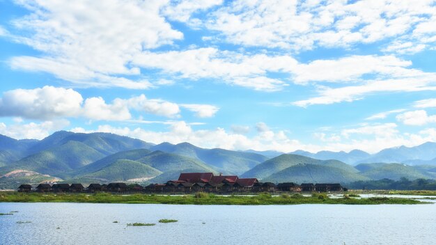 A casa flutuante de pessoas inle no lago inle, com um lindo céu, pode usar o inimigo para promover o turismo na vila inla em mianmar.