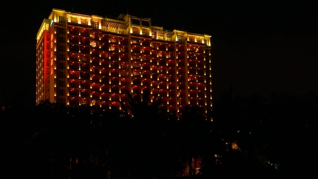 A cena noturna escura de um prédio comercial ou hotel com luzes