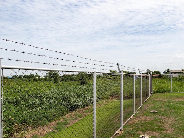 A cerca de metal com a espinha no topo para a segurança do intruso ao redor da área do armazém vista frontal com o espaço de cópia