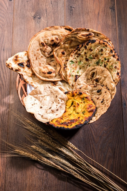 A cesta de pães indianos variados inclui chapati, tandoori roti ou naan, paratha, kulcha, fulka, missi roti