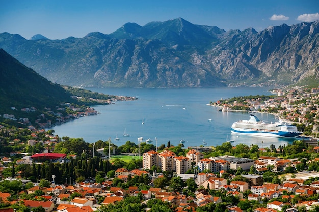 A cidade de Kotor em Montenegro e a baía de Kotor com um grande navio de cruzeiro de um ponto de vista aéreo