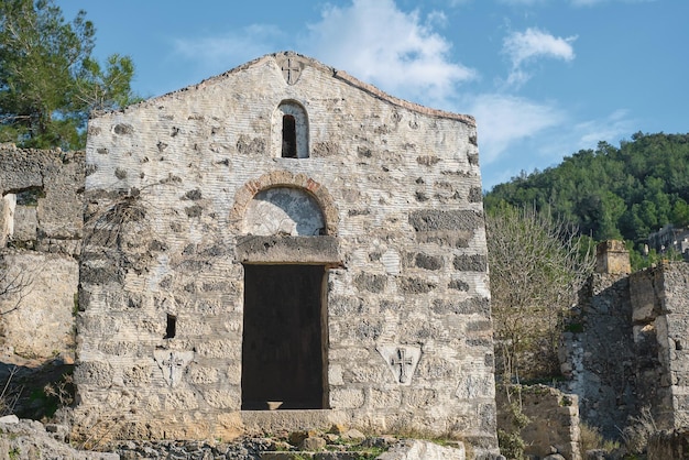 A cidade fantasma abandonada de Karmilisos, perto da aldeia de Kayakoy, na Turquia, as ruínas de casas de pedra Local da antiga cidade grega