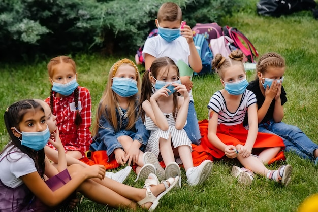 A classe de alunos mascarados está envolvida em treinamento ao ar livre durante a epidemia