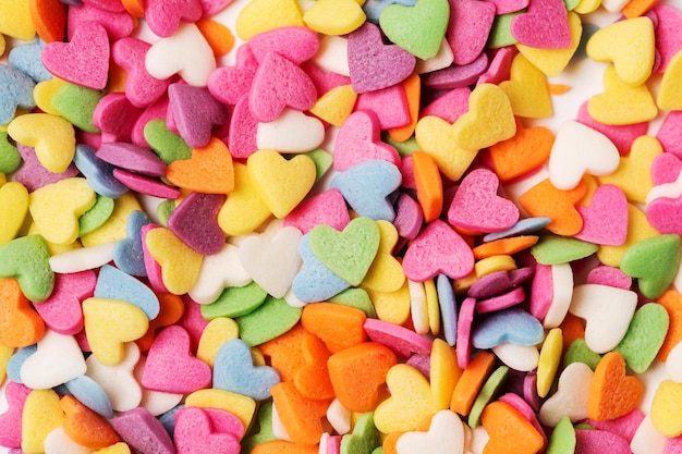A cobertura de pastelaria multicolorida em forma de coração borrifa o cartão de saudação minimalista do dia de São Valentim