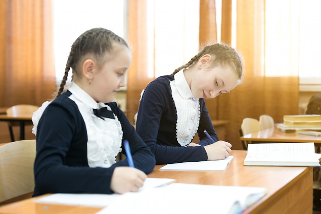 A colega de classe olha no caderno de outra pessoa.