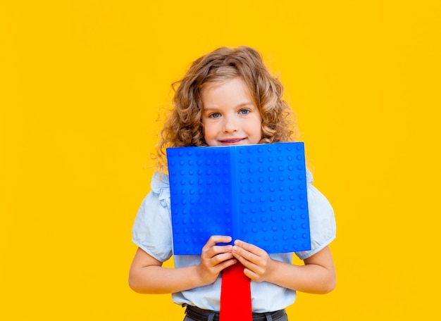 A colegial assustada cobriu o rosto com um livro azul. colegial com livro perto do rosto