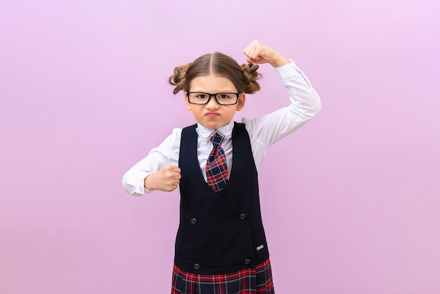 A colegial está muito zangada. Uma criança com uniforme escolar é infeliz. uma garota em um fundo isolado.