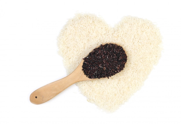 A colher do arroz preto (arroz de burry) e o arroz do jasmim no coração dão forma, isolado no fundo branco.