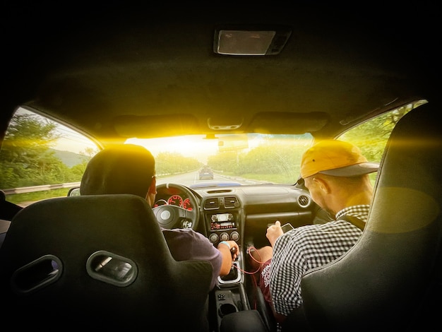 Foto a começar a viagem de carro, dois caras sentados nos bancos da frente