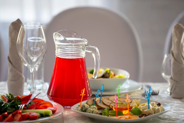 A comida está na mesa de reston compota vermelha em um decantador de vidro e lanches na mesa