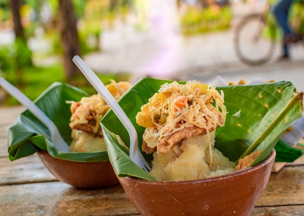 A comida típica vigoron de Granada Nicarágua Vigoron tradicional em folhas de bananeira servido em uma mesa de madeira Nicarágua conceito de comida Closeup de dois vigorones servidos em uma mesa de madeira