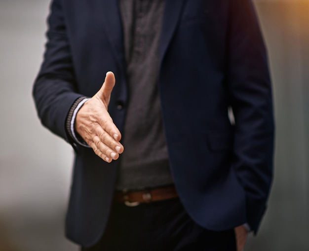 A confiança é o primeiro passo para o sucesso Foto recortada de um empresário estendendo o braço para um aperto de mão