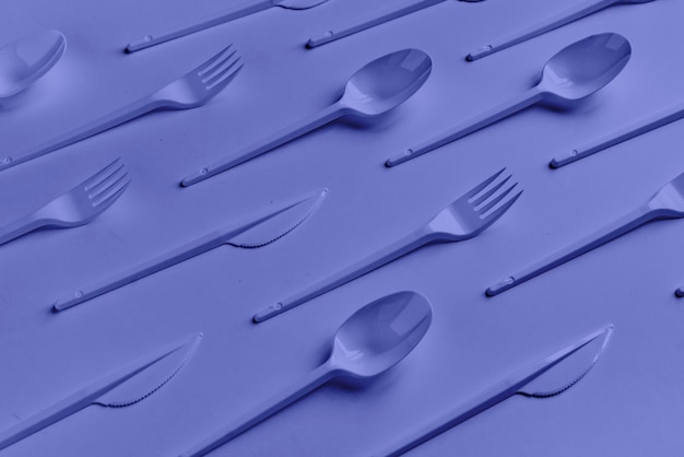 A configuração plana criativa do padrão de colheres e facas de garfos de plástico