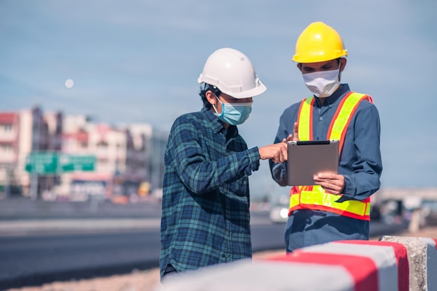 A construção do engenheiro asiático é um trabalhador que trabalha com capacete de controle de segurança na construção do local