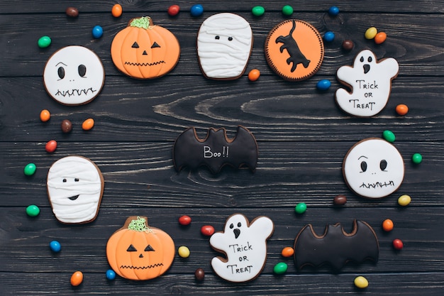 A cores de doces e assustadores gingerbreads para Halloween em um fundo de madeira preto.