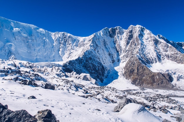 A Coroa do pico da montanha de Altai Belukha Vista da montanha Montanhas de Altai Geleira Akkem Bela vista da superfície da geleira com gelo e rochas Superfície da morena de gelo da geleira