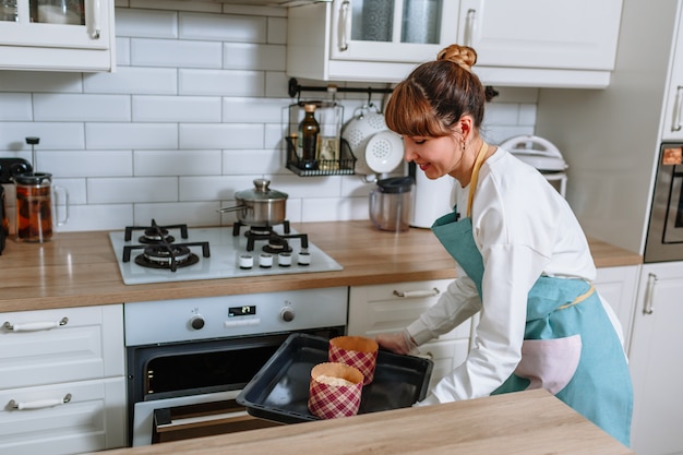 A cozinheira está se preparando para colocar os formulários com bolos de Páscoa no forno