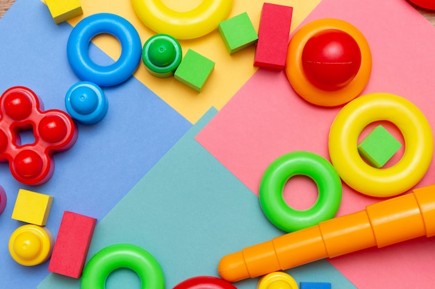 Foto a criança colorida caçoa o espaço da cópia do fundo do teste padrão dos brinquedos da educação no brilhante.