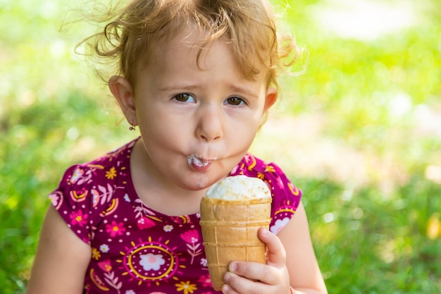A criança come sorvete na rua Foco seletivo