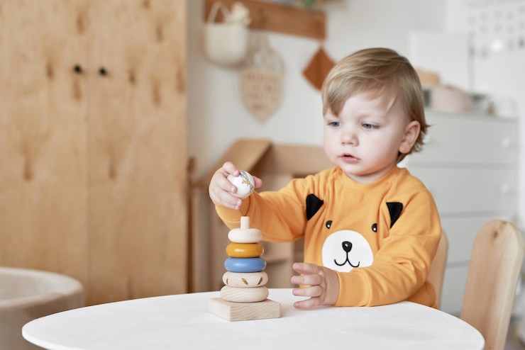 Foto a criança do bebê brinca com a pirâmide de brinquedos de madeira desenvolvimento inicial