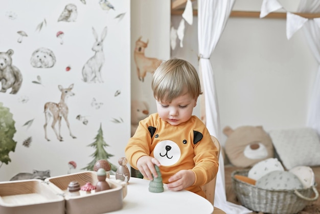 A criança do bebê brinca com brinquedos de madeira Desenvolvimento inicial