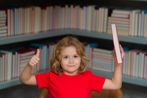 A criança do conceito da escola e da educação lê livros no estudante da biblioteca com o livro na biblioteca da escola li