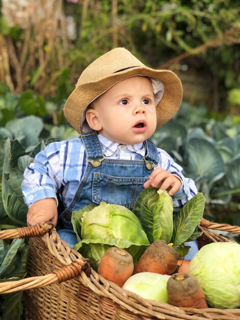 A criança é um pequeno agricultor. Assistente de fazenda.