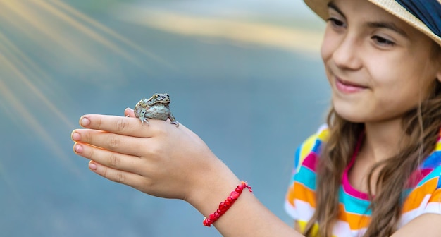 A criança está brincando com o sapo foco seletivo