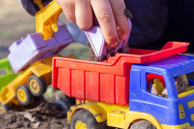 A criança está brincando na rua com areia