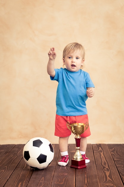 A criança está fingindo ser um jogador de futebol. Conceito de sucesso e vencedor