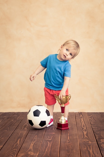 A criança está fingindo ser um jogador de futebol. Conceito de sucesso e vencedor