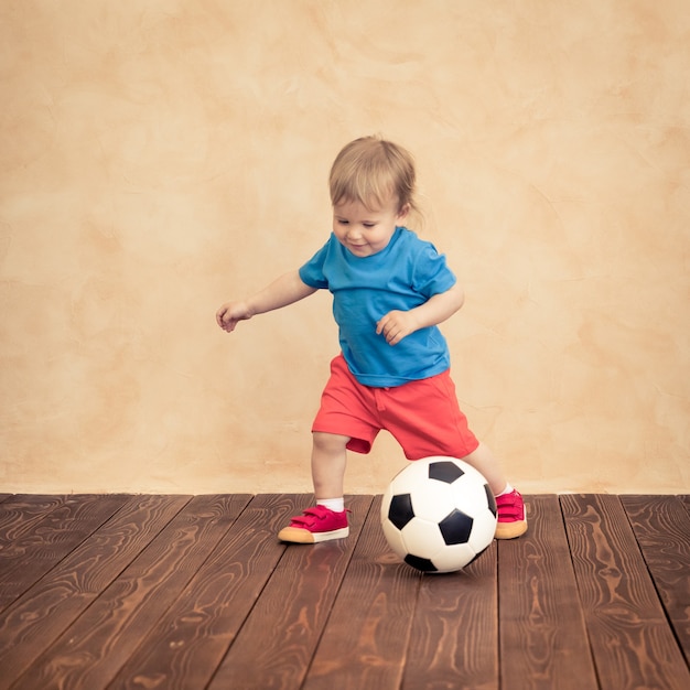 A criança está fingindo ser um jogador de futebol. Conceito de sucesso e vencedor