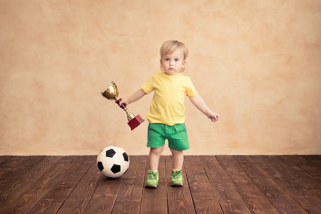 A criança está fingindo ser um jogador de futebol. Conceito de sucesso e vencedor